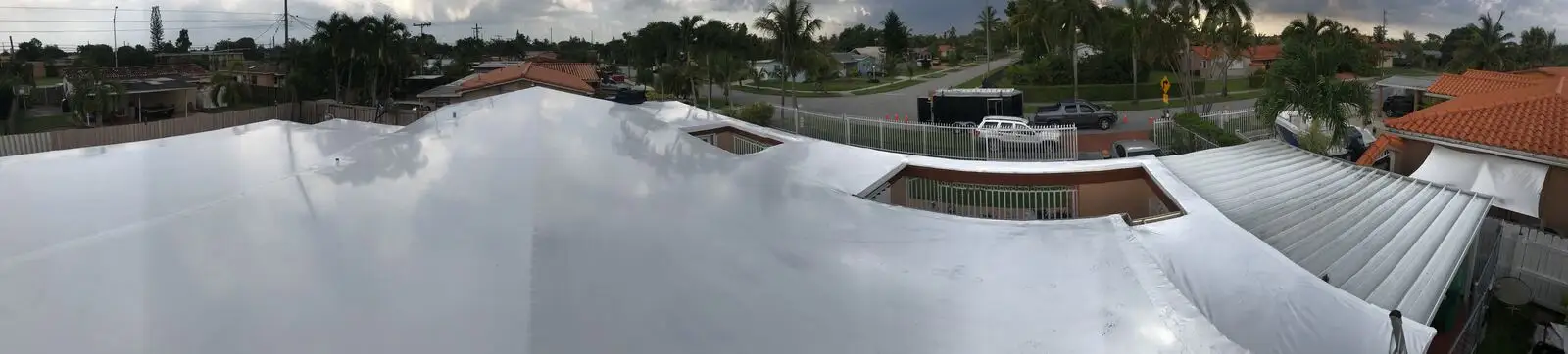Professional shrink wrap roof installation creating watertight barrier for extended Florida storm protection