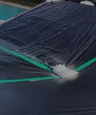 Emergency roof tarping setup on a storm-damaged property.