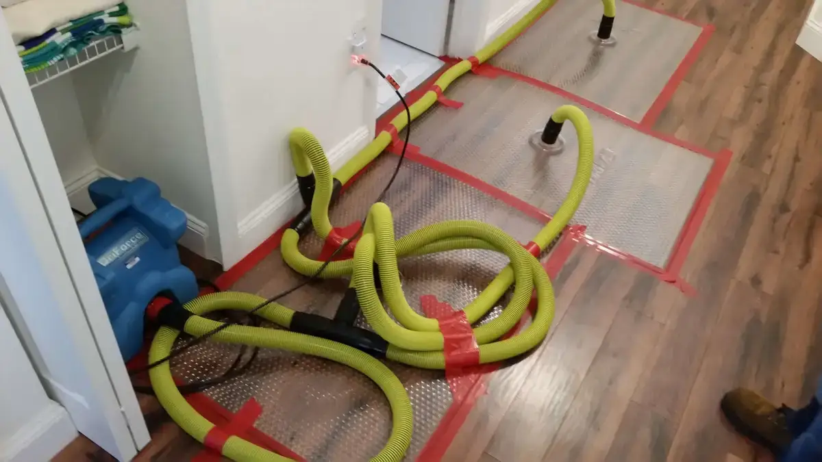 Wet flooring being dried with professional water damage equipment.