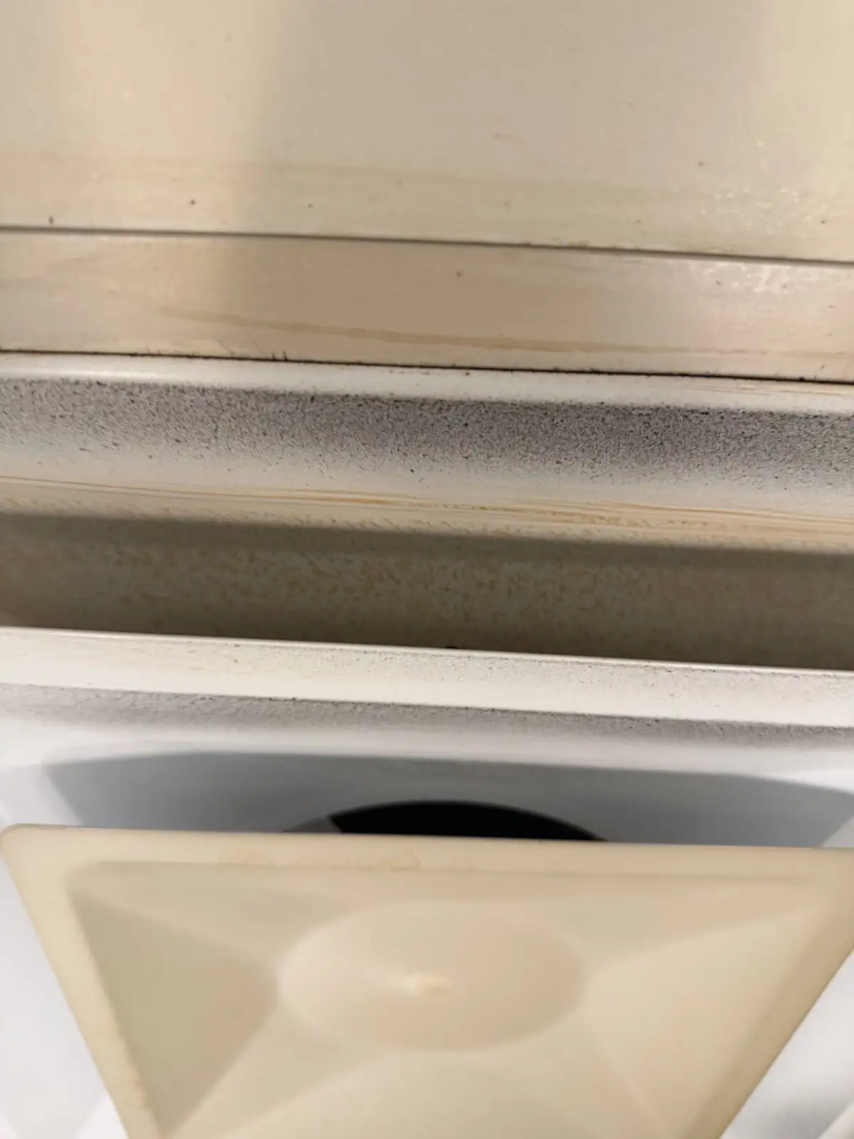 Close-up of an ice-machine interior with mold and yellowish mineral soil.