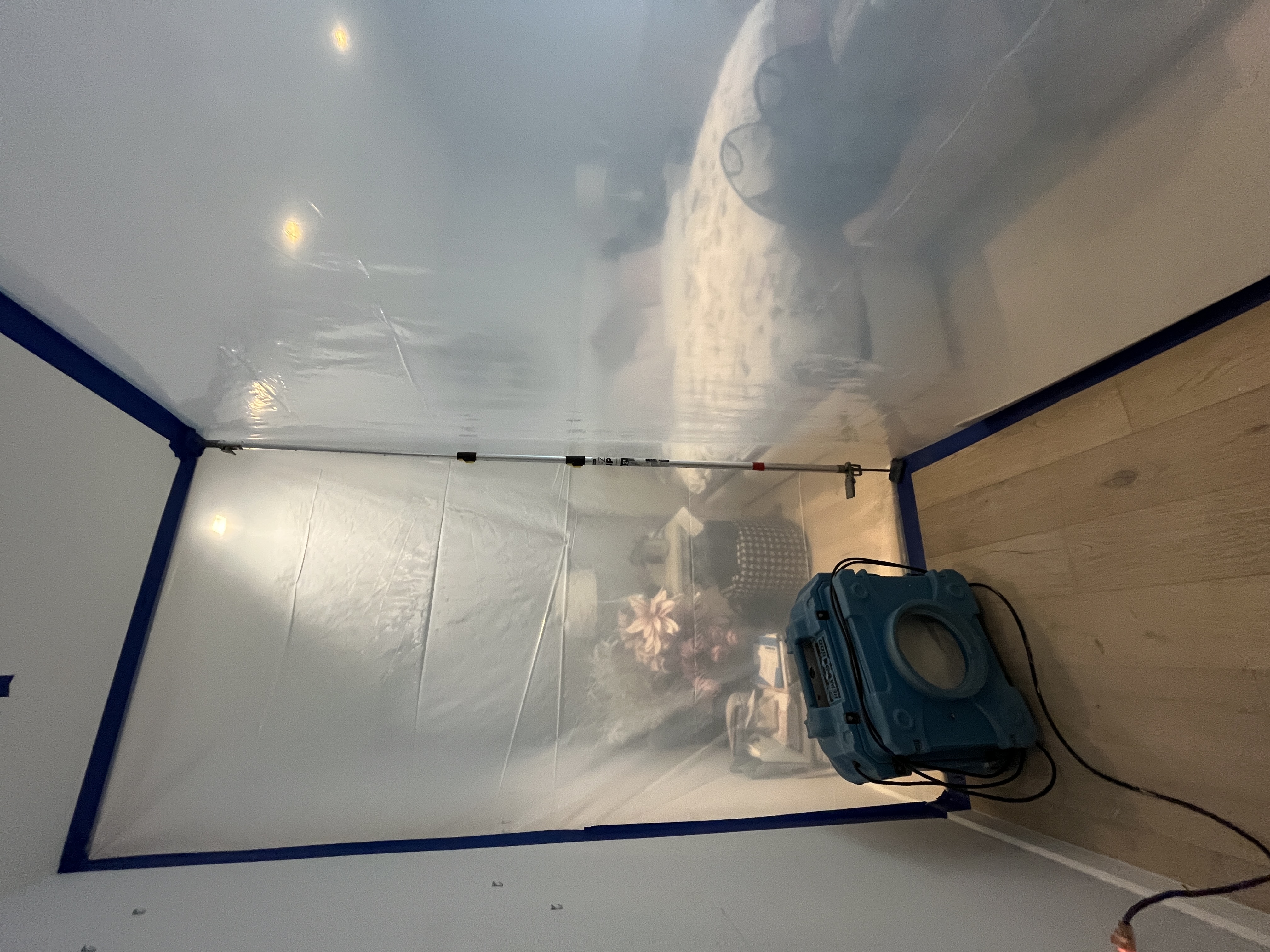 Professional mold containment area setup in bedroom with plastic sheeting barriers for safe remediation