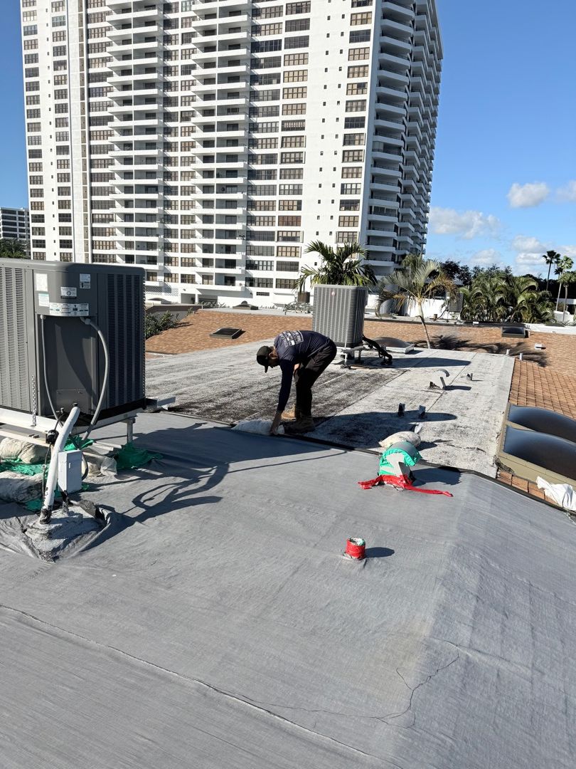 Professional commercial roof tarp installation showing secure tarping technique
