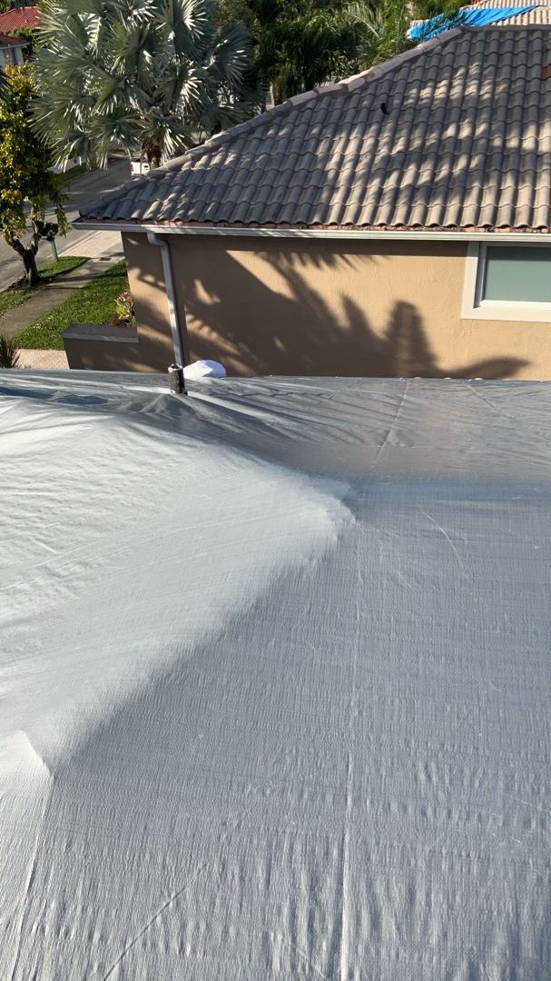 Professional grey tarp installation on damaged roof