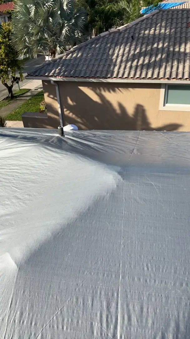 Grey tarp installed on damaged roof for emergency protection during hurricane season