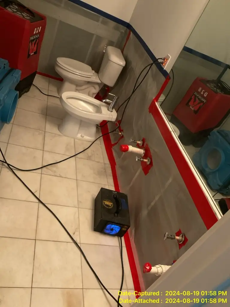 Bathroom water damage restoration with drying equipment setup